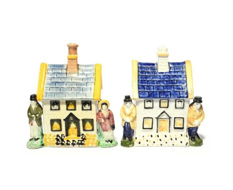 Two pearlware cottage money boxes, 19th century, each modelled as a small house with children peeping from the upper windows,