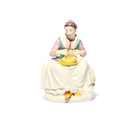 A Meissen model of the lace maker Barbara Uttman, c.1745, modelled by J F Eberlein, resting her lacemaking pillow on her knee