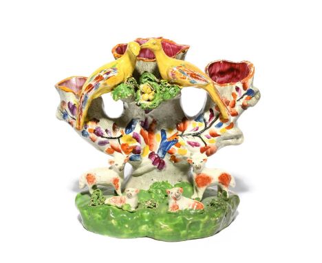 A Staffordshire spill vase, 1st half 19th century, modelled as a hollow tree trunk with three openings, a pair of brightly co