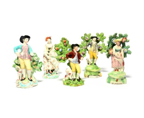 A pair of Derby porcelain figures of a shepherd and shepherdess, c.1765-70, modelled with a sheep and a dog, and three pearlw