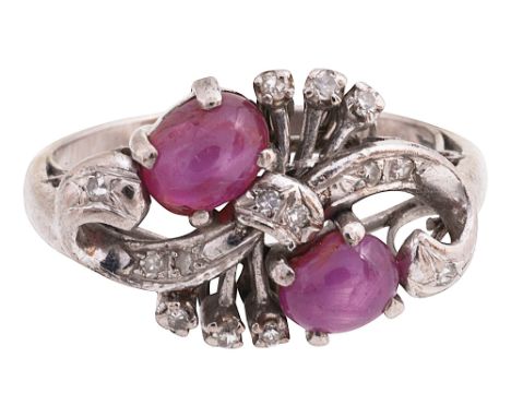 A ruby and diamond-set ringset with two oval ruby cabochons to the diamond-set openwork 'S' scroll surround, the shank stampe