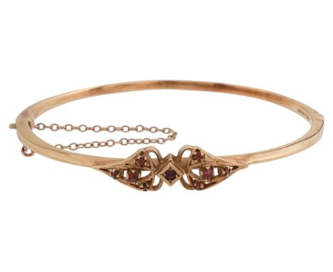 A 1970s 9ct gold and garnet set bangle stamped '375', with safety chainapprox diameter 6.3cm, approx weight 12.9gCondition: I