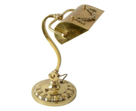 An Edwardian brass banker's lampthe adjustable hood with an applied garland, on an S-scroll adjustable support swivelling in 