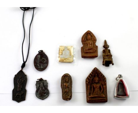 Nine Eastern Buddhist amulets, various dates and in assorted media to include metal, wood, ceramic etc (9).