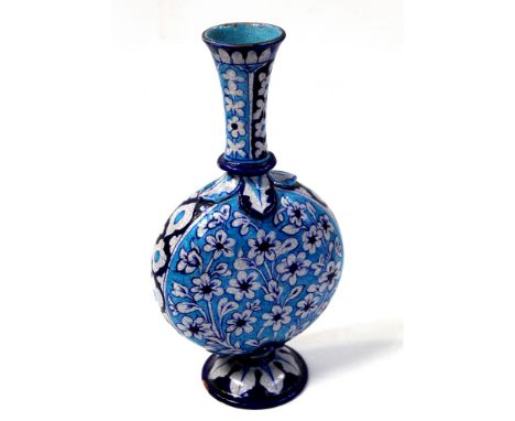 An early 20th century long neck Persian moon flask with floral decoration in dark blues and white to a turquoise blue ground,