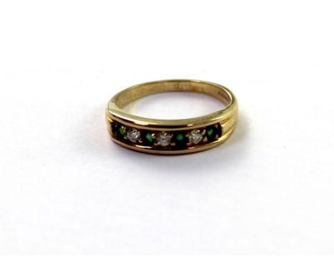 A 9ct yellow gold ladies' dress ring, platform-set with four small emeralds and three white stones, size P, approx 2.7g.