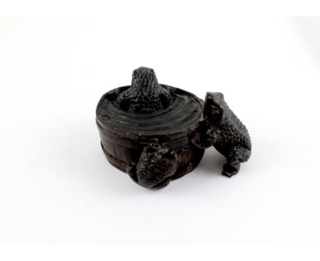A Japanese hardwood carved netsuke of a washtub with three frogs.