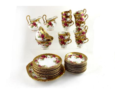 A rose pattern tea service. CONDITION REPORT One cup with hairline crack, slight rubbing to some pieces, though generally goo