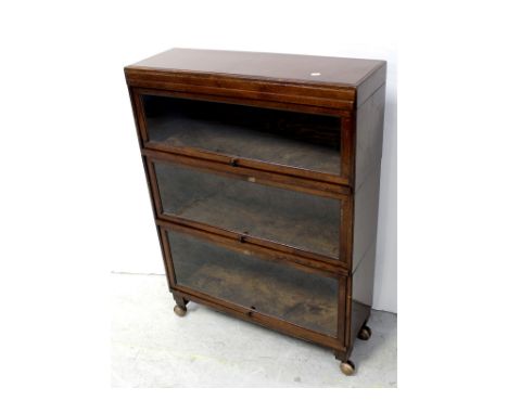 An Art Deco period oak three-section stacking bookcase, on later shepherd's castors, height 117.5cm.