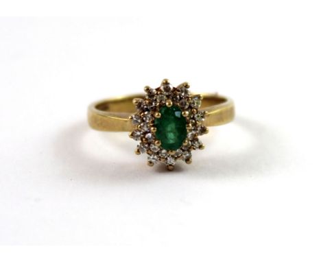 A 9ct yellow gold ladies' dress ring, floral-set with central oval emerald and small diamond surround, size N, approx 2.9g.