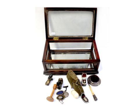 An early 20th century bijouterie case of small proportions with glass base containing mostly sewing-related items to include 