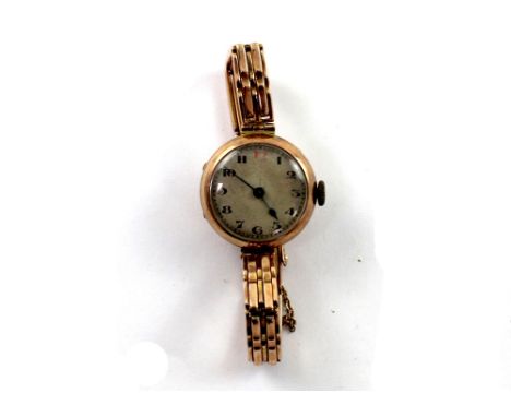 A vintage 9ct gold ladies' wristwatch, the silvered dial set with Arabic numerals, on a gold plated bracelet link strap.
