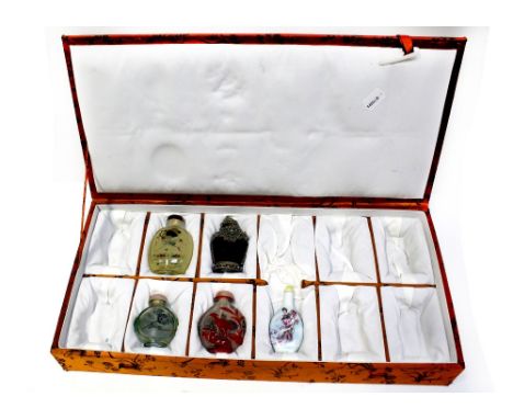 A case containing five Chinese snuff bottles to include glass, ceramic, hand-painted and metal embellished examples (5).