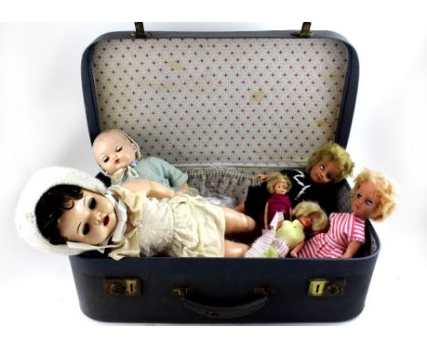 A vintage suitcase containing dolls, mainly dating from the 1950s and 60s and a quantity of handmade dolls' clothes.