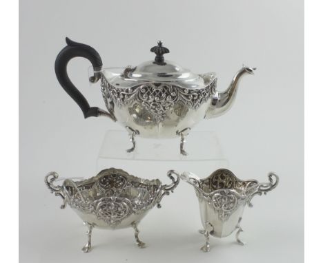 A Victorian hallmarked silver bachelor's tea service, teapot, milk jug and sucrier with foliate scroll repoussé and chased de