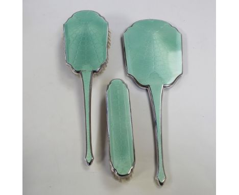 An early/mid-20th century white metal and green guilloché dressing table set, hand mirror and two hair brushes, two commemora