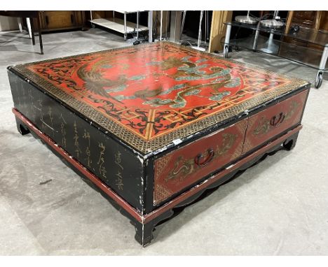 A Chinese red and black lacquer low table, gilded and decorated with dragons; ho-ho birds; flaming pearls and auspicious obje