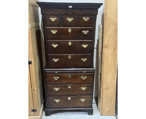 An antique oak chest on chest with brushing slide and canted sides, raised on bracket feet. 29"w x 66" h.