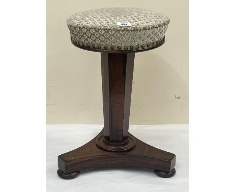 An early Victorian rosewood piano stool, the upholstered seat on faceted column and tripartite base.