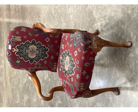 An early 20th century walnut armchair upholstered in a tapestry fabric with shepherd crook arms on moulded cabriole legs.