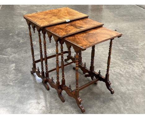 A walnut nest of three occasional tables on bobbin turned slender legs. 27" high