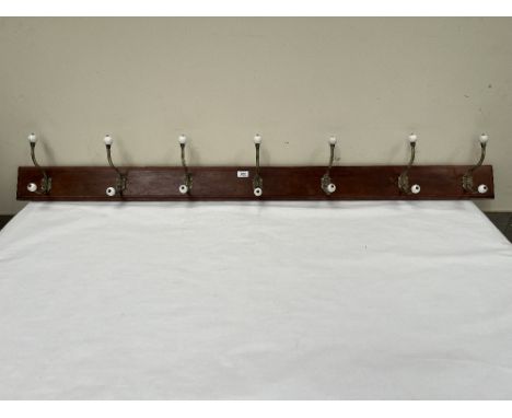 A set of Victorian style brass and ceramic coat hooks. 66" long.