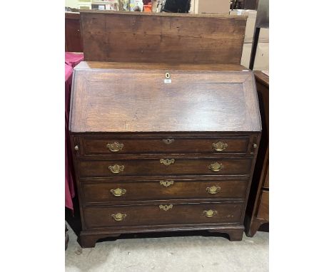 A George III oak bureau with fitted interior on bracket feet. 41" wide.