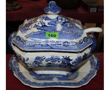 	A Victorian soup tureen, cover and stand, transfer printed in blue and white in the Willow Pattern. 12' high (the associated