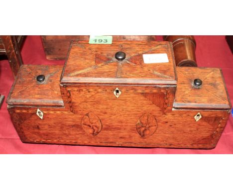 	A 19th Century oak inlaid tea caddy of stepped form, the three lids over boxwood oval cartouches, on turned feet. 14 ¾' wide