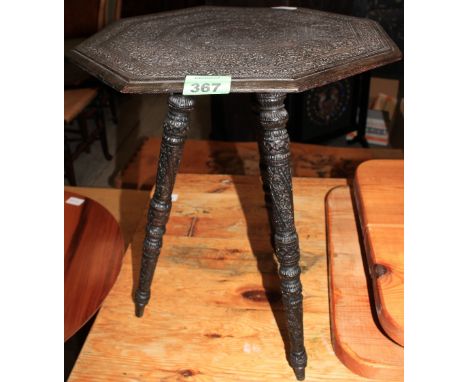 An Indian ebony carved tripod table