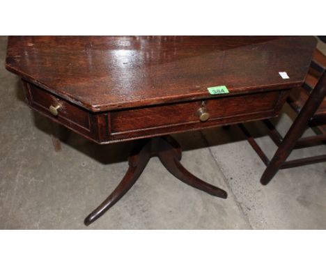 	A George III oak octagonal drum table with two real and six false drawers, on ring turned baluster column and tripod support