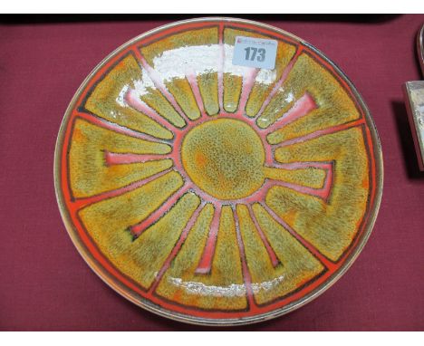 A Poole Studio Pottery Bowl, painted with a red sunburst design on a mottled ochre ground 20.5cm diameter.