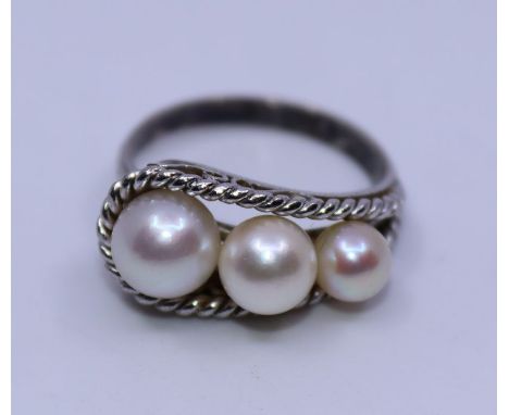 A white metal and cultured pearl ring, set row of three graduated cultured pearls within filigree work border and gallery, (w