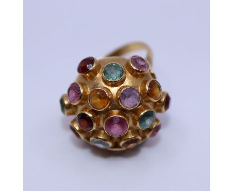 An 18ct. gold and multi gemstone set dress ring, of hemi-spherical form bezel set numerous different coloured gemstones, weig