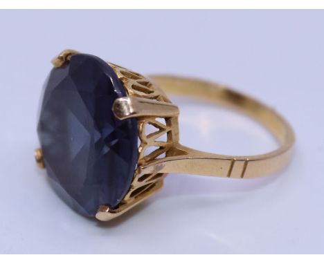 An 18ct. yellow gold and synthetic amethyst cocktail ring,&nbsp;c.1970's, four claw set large mixed round cut synthetic ameth