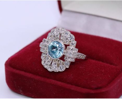 An Art Deco blue zircon and diamond platinum dress ring, the pierced rectangular head set central round cut zircon and numero