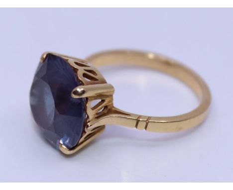 An 18ct. yellow gold and synthetic amethyst cocktail ring, four claw set large round mixed cut synthetic amethyst, gross weig