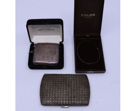 A collection of white metal items to include silver ingot necklace, a white metal bangle and two white metal pill cases (4) w