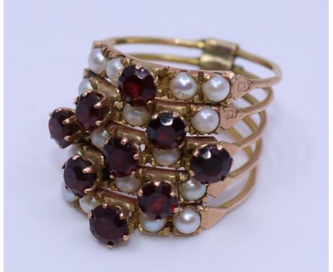 A 14ct. gold, pearl and garnet six section hareem ring,&nbsp;weight, 6.4g, size M