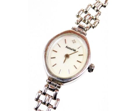An Accurist 9ct white gold ladies wristwatch, with oval silvered colour dial set with tiny diamond, on a fancy gate style bra