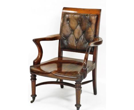 A 19thC mahogany smoker's chair, with a brown leather button back, solid seat, raised on turned legs, brass capped on castors
