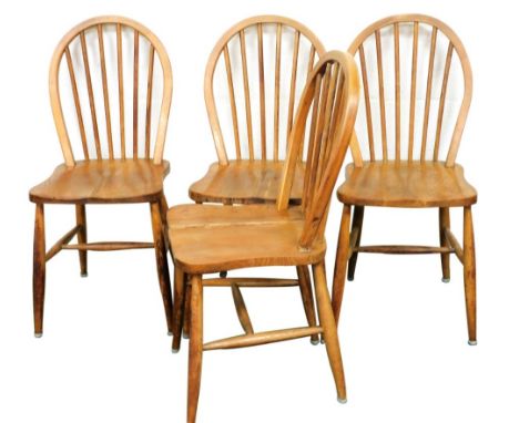 A set of four Ercol mid 20thC  beech and elm stick back chairs, with utility mark and printed labels. 