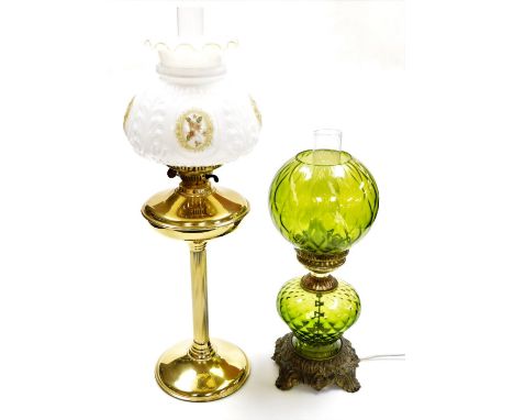 A 20thC brass effect oil lamp with shade, 69cm high, and a table lamp of oil lamp form, with green glass reservoir and shade,