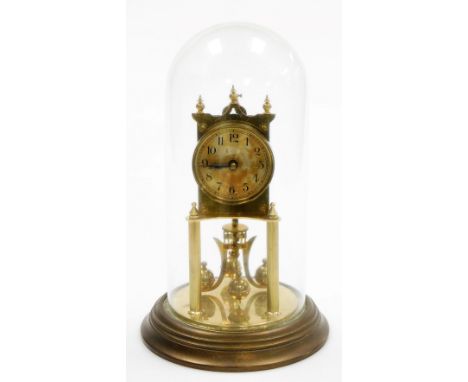 An early 20thC German brass anniversary clock, in a glass dome, with a 6.5cm brass Arabic numeral dial, 31cm high overall.