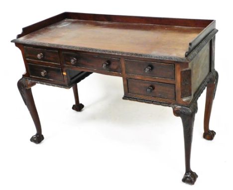 An early 20thC Chippendale style mahogany dressing table, with three part galleried back, with a heavily carved acanthus leaf