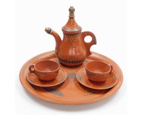 A Turkish terracotta part tea set, decorated in gilt and dark brown, comprising circular tray, teapot and cover and pair of t