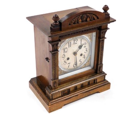 An early 20thC walnut cased mantel clock, with a silvered square dial, brass spandrels, silvered chapter ring bearing Arabic 