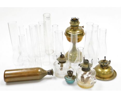 An early 20thC brass oil lamp base, 27cm high, various glass chimneys, glass oil lamp bases, etc. (a quantity)