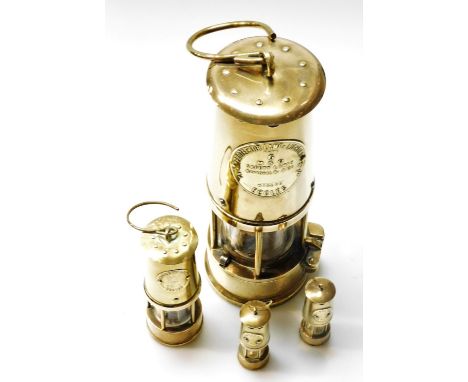 A brass Protector and Lighting Company limited miners lamp type six, and three miniature brass miners lamps. (4) 