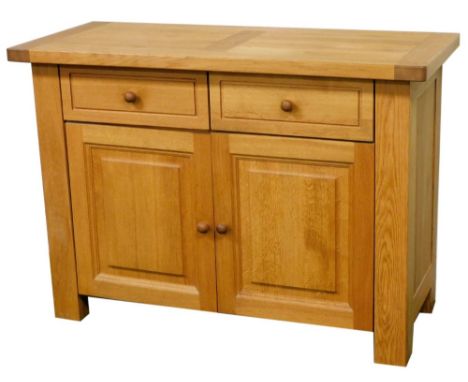 A light oak sideboard, with two panelled drawers above two hinged doors, with turned wooden handles, on stile feet, 84.5cm hi